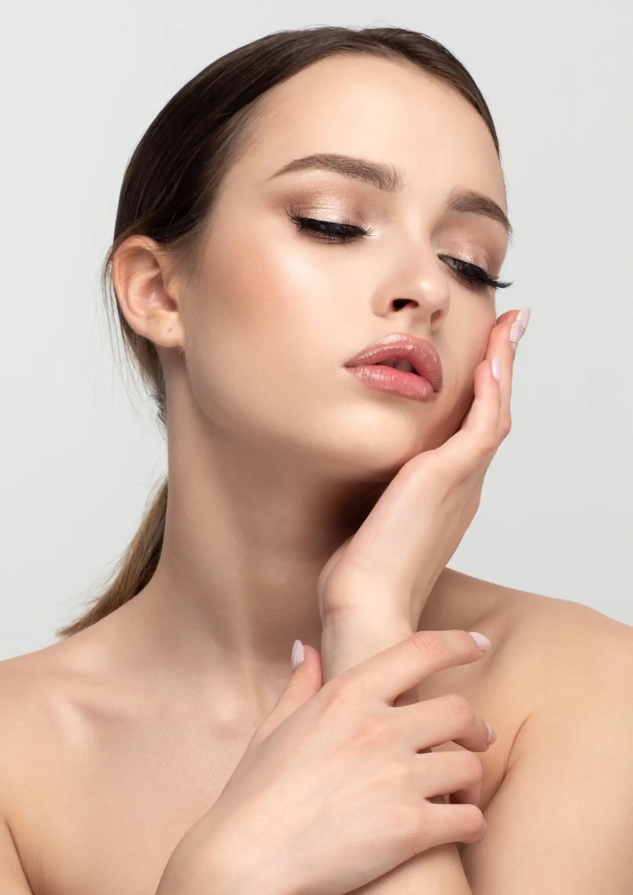 Donna con pelle liscia e luminosa si sfiora il viso