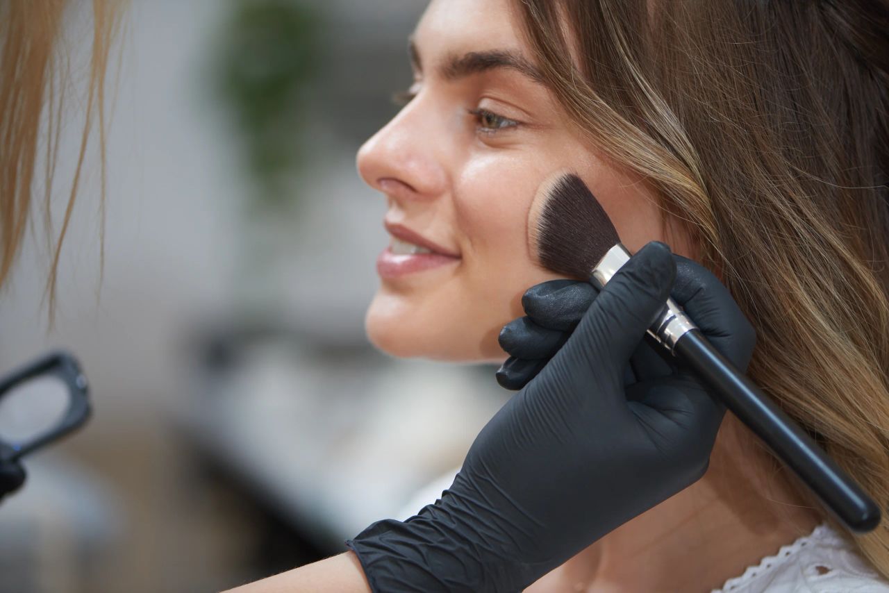 Applicazione del blush con il pennello durante una seduta di trucco
